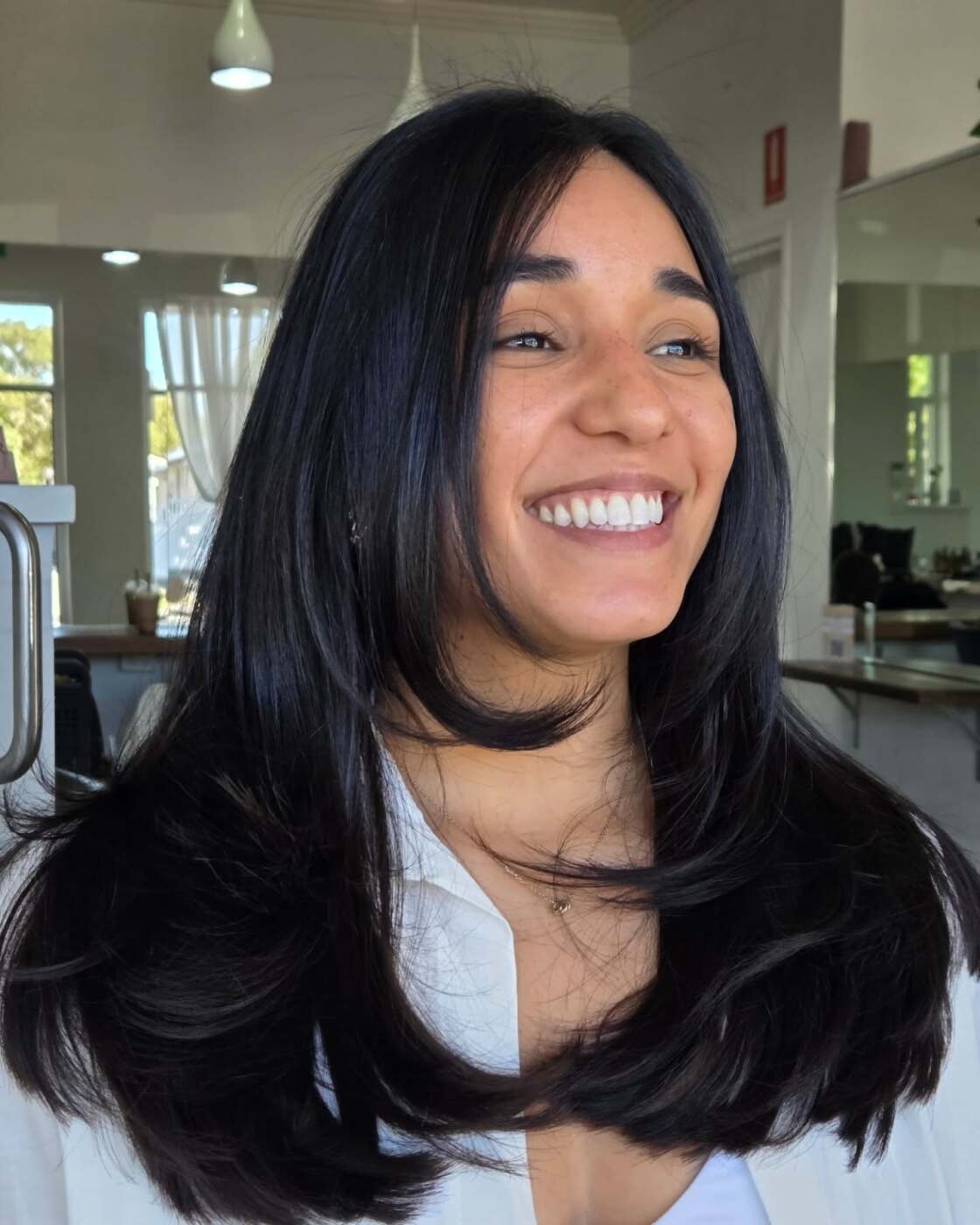 Long black hair with soft layers and a curtain fringe